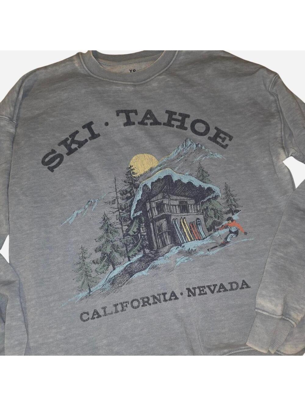 Gray crewneck sweatshirt with graphic of a ski lodge with skiers